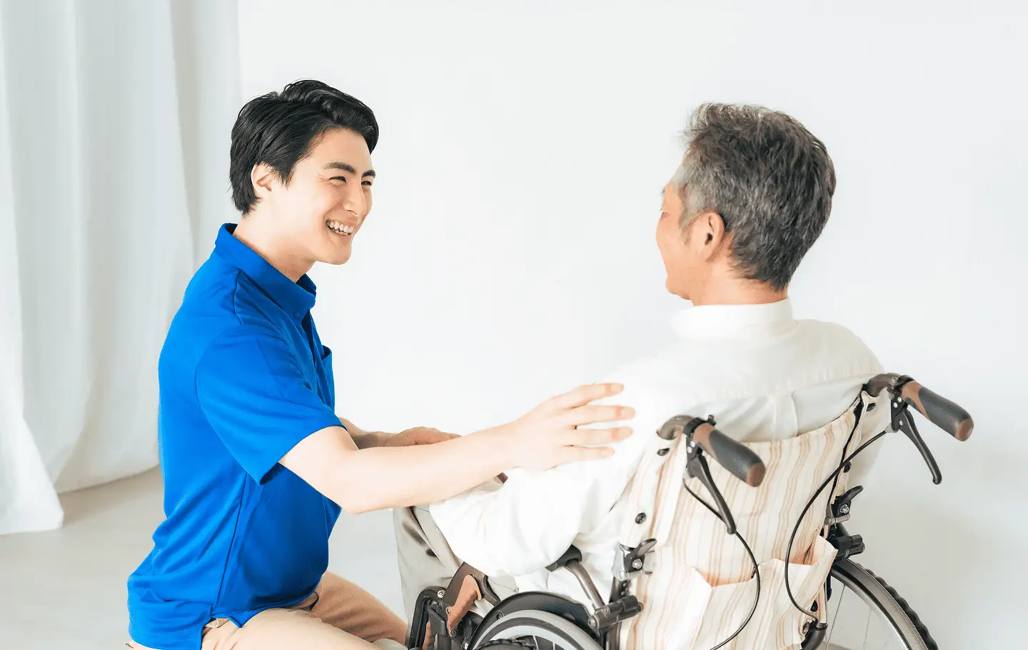 車椅子に乗っている男性と話している男性