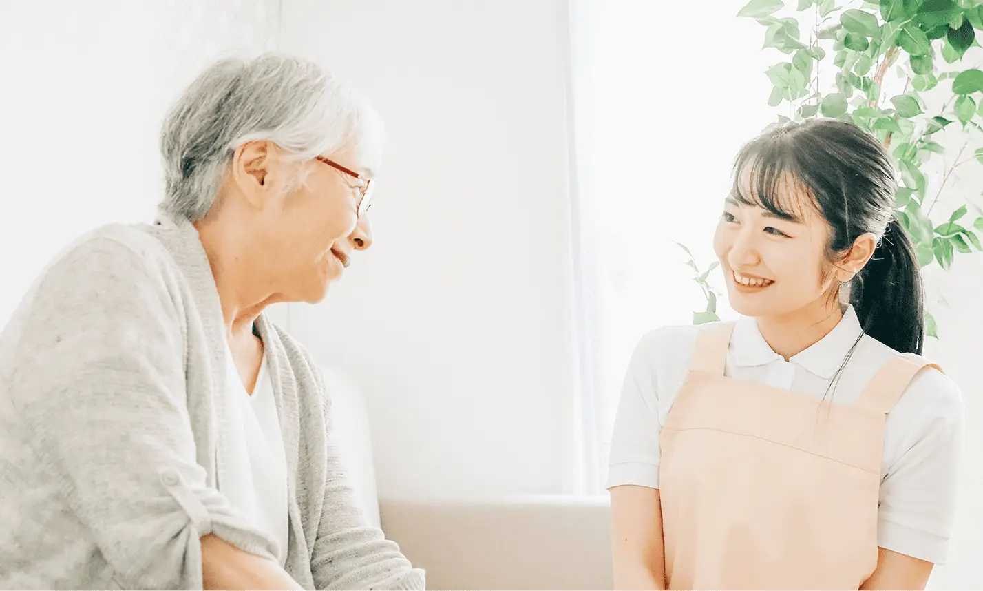 二人も女性が顔を見合わせて微笑みあっている画像