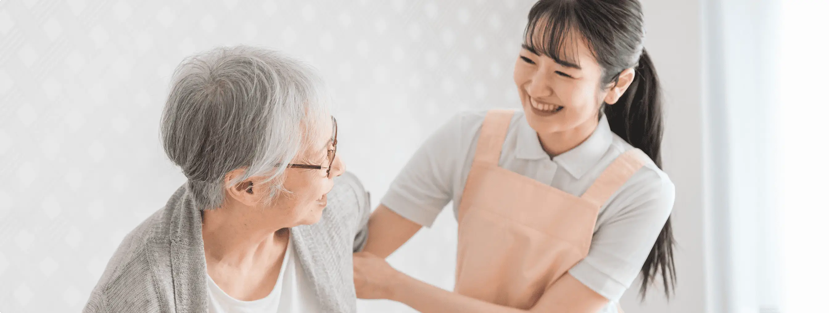 高齢の女性をサポートをしている若い女性
