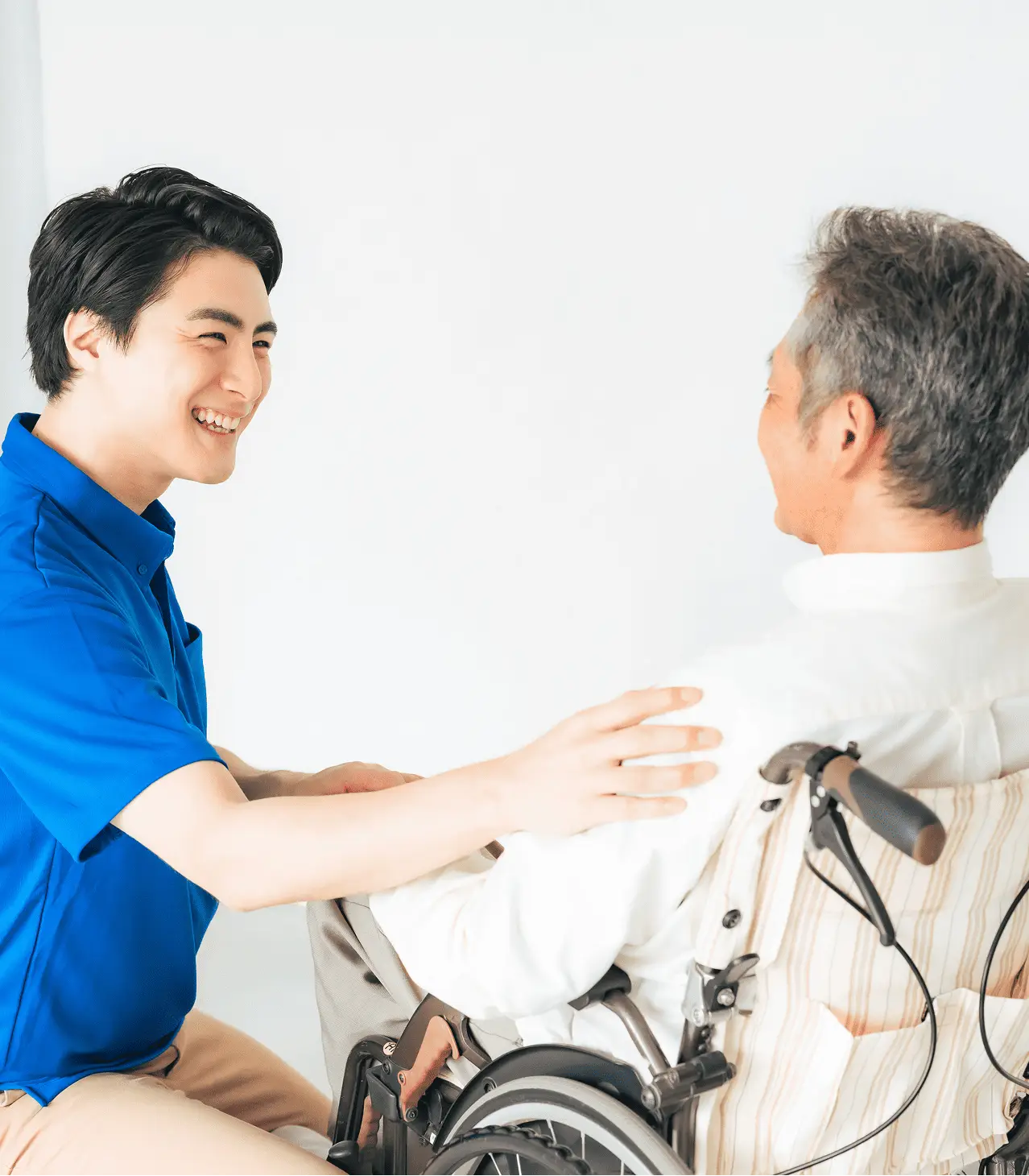 車椅子に座っている男性とそばにいる介護士の男性