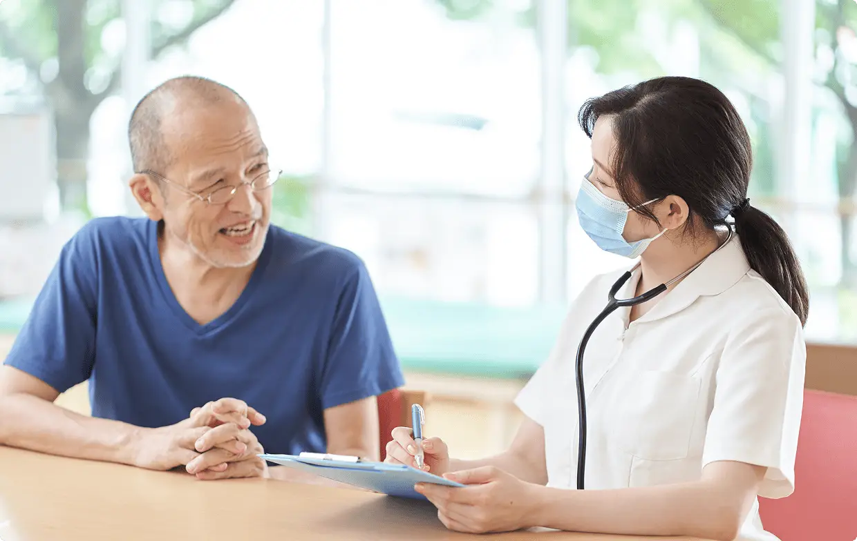 高齢男性と看護師が話している画像